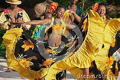 People wearing colorful dresses perform traditional creole Sega dance at sunset in Ville Valio, Mauritius. Editorial Stock Photo