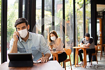 People wearing surgical masks are sitting in restaurants, coffee shops. social distancing concept Healthcare pandemic. Public Stock Photo