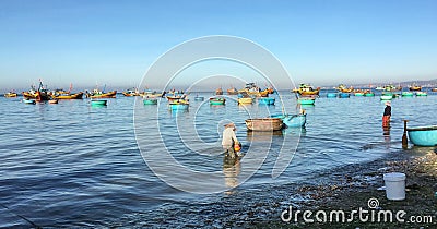 People working on the beach with many fishing boats in Phan Rang, Vietnam Editorial Stock Photo