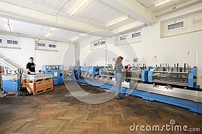 People working on a brochure and magazine stitching process mach Editorial Stock Photo