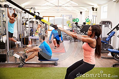 People working out on fitness equipment at a busy gym Stock Photo