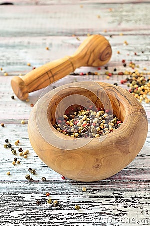 Peppercorns in a mortar on light wooden table Stock Photo