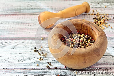 Peppercorns in a mortar on light wooden table Stock Photo