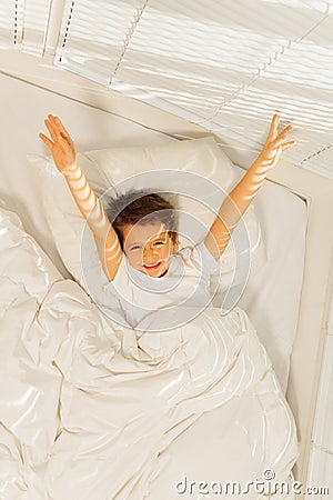 Peppy kid boy waking up in his white bedroom Stock Photo