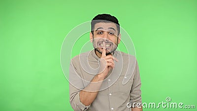 Per favore, state zitti. Brunetta positiva che fa gesti di silenzio con un dito sulle labbra sfondo verde, chiave chroma video d archivio Per favore, state zitti. Brunetta positiva che fa gesti di silenzio con un dito sulle labbra sfondo verde, chiave chroma video d archivio