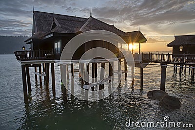 Slow exposure shot of the golden hour of the unique architectural wooden houses or villas on stilts by the sea Editorial Stock Photo