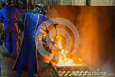 perator pouring molten metal in automatic casting line in foundry factory Stock Photo