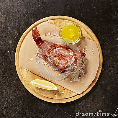 Perch served on piece of parchment and wooden board Stock Photo