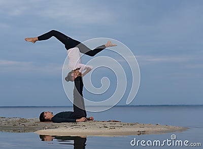 Perfect acroyoga. Beautiful young couple is doing yoga Stock Photo