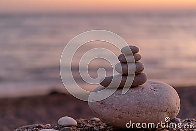Perfect balance of stack of pebbles at seaside towards sunset. Stock Photo