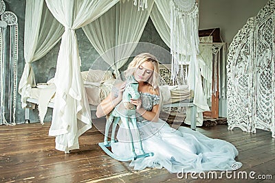 Perfect Blonde Woman Sitting on Wooden Floor Stock Photo