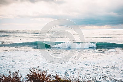 Perfect breaking ocean barrel wave and surfers Stock Photo