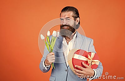 It is perfect. gift for mothers or womens day. happy man with tulip flowers. gentleman hold bouquet and heart box Stock Photo