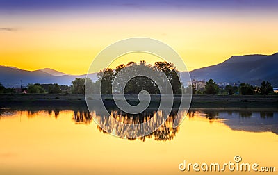 Perfect golden hour sunset over calm, reflective lake Stock Photo