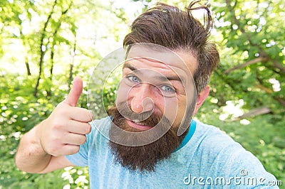 Perfect hair length for his face shape. Happy man with styled hair giving like hand. Hairy guy with stylish mustache and Stock Photo