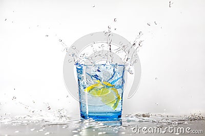 Perfect lemon splash in a blue glass of water Stock Photo