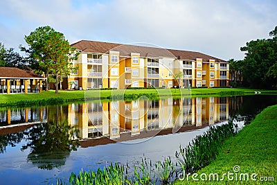 Perfect mirror reflection: Yellow condos or apartments and a small pond Stock Photo