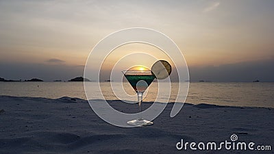 Perfect sunset on top of the mocktail served in martini glass at the whitesand beach Stock Photo