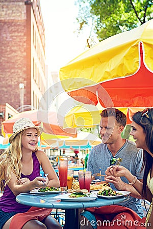 The perfect way to kickstart summer. three young friends sitting at an outdoor cafe. Stock Photo