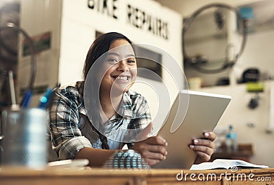 Perfectly content. Portrait of a young woman using a digital tablet at work. Stock Photo