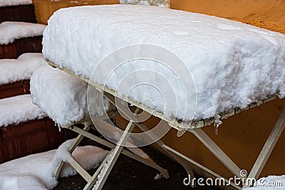 Perfectly shaped snow on table and chairs, covered with snow Stock Photo