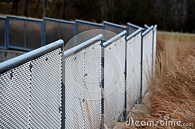Perforated expanded metal sheet metal fencing. Very durable railing made of galvanized railing frame. The strip of ornamental gras Stock Photo