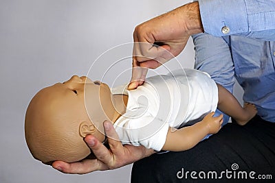 Performing cpr on a simulation mannequin baby dummy during medical training Pediatric Basic Life Support Stock Photo