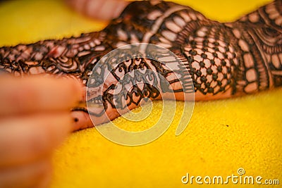 Performing mehandi or henna design on female hand close up image isolated Stock Photo