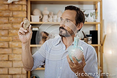 Blue-eyed ceramist working hard while performing order for clients Stock Photo