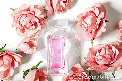 Perfume bottle in pink flower roses. Spring background with luxury aroma parfume. Beauty cosmetic shot Stock Photo