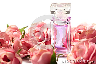 Perfume bottle in pink flower roses. Spring background with luxury aroma parfume. Beauty cosmetic shot Stock Photo