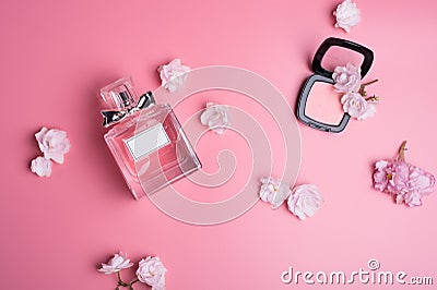 Perfume bottle with soft pink blush around flowers on pink background. flat lay Stock Photo