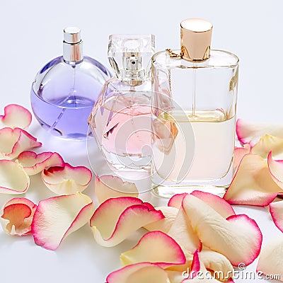 Perfume bottles with flower petals on light background. Perfumery, fragrance collection. Women accessories. Stock Photo