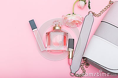 Perfume, lip gloss, lipstick and bag on a pink background Stock Photo