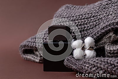 Perfume, Men`s perfume or lation After shave on a brown background next to a men`s sweater and a cotton ball, Luxury, Gift. Clos Stock Photo