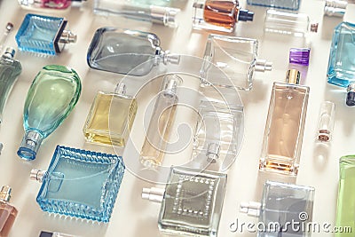 Perfumery, cosmetics and beauty industry background. A lot of transparent bottles of perfume and cologne and toilet water lie Stock Photo