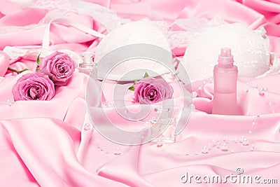 Perfumes with roses and women underwear on pink silk Stock Photo