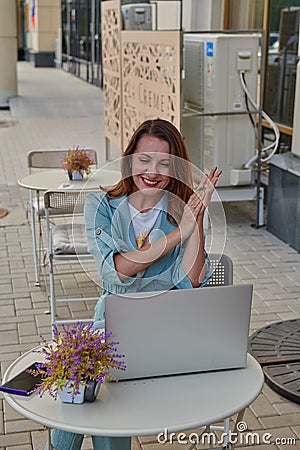 perky girl at a table in a cafe with a laptop Stock Photo