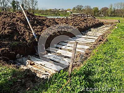 Permaculture trench construction with half long logs of wood Stock Photo