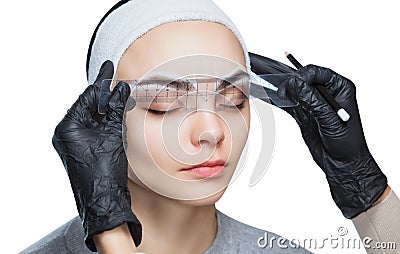Permanent make-up for eyebrows of beautiful woman with thick brows in beauty salon Stock Photo