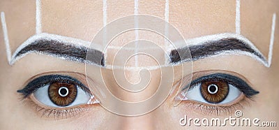 Permanent make-up for eyebrows of beautiful woman with thick brows in beauty salon. Stock Photo