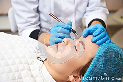 Permanent make-up wizard makes eyebrow correction procedure. Microblading Stock Photo