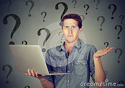 Perplexed man with laptop many questions and no answer Stock Photo