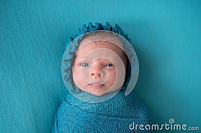 Perplexed Newborn Baby Girl Wearing a Turquoise Blue Bonnet Stock Photo