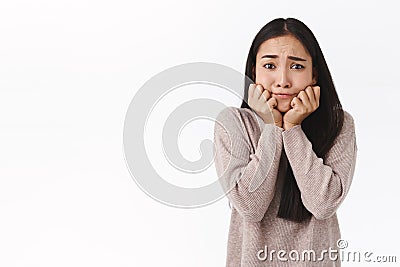 Perplexed, worried silly cute adorable asian girl with dark long hair, hold hands on jawline look indecisive and sad Stock Photo