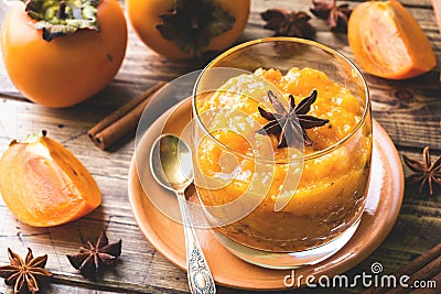 Persimmon fruit smoothie with cinnamon and anise stars, wooden table Stock Photo