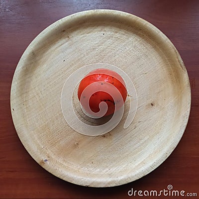 Persimmon on wooden tray on wooden table Stock Photo