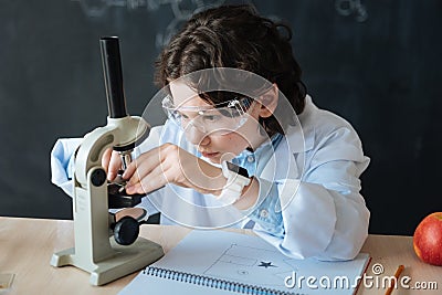 Persistent little scientist taking part in microbiology experiment at school Stock Photo