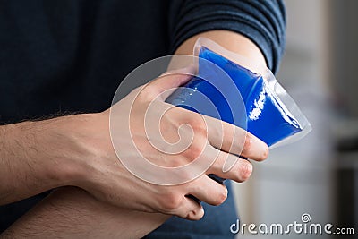 Person Applying Ice Gel Pack On An Injured Elbow Stock Photo