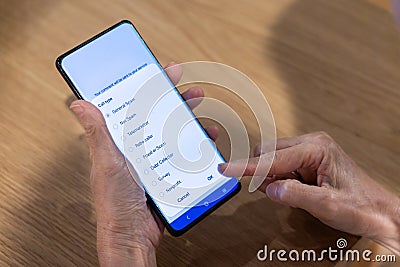 Person attempting to report calls received as general spam to mobile network, and concurrently block the caller Stock Photo
